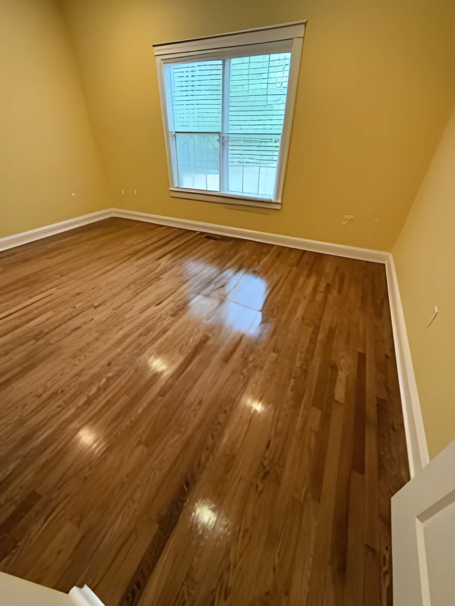 Refinished hardwood bedroom floor with stained finish
