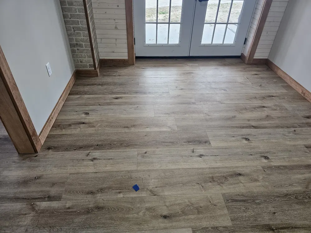 Luxury vinyl plank flooring in an entry with French doors and wood trim in Rice Hope, Rincon GA