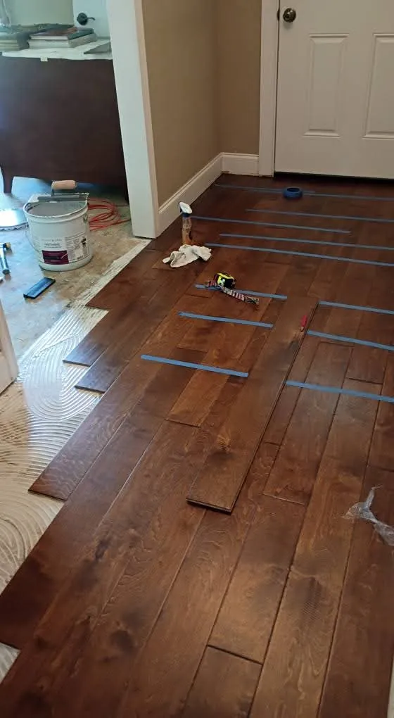Engineered wood planks taped during glue-down installation in the Downtown District, Springfield GA