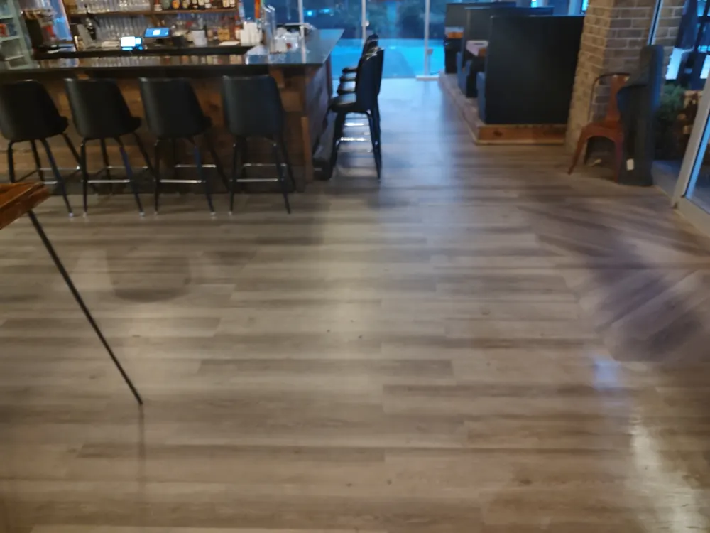 Commercial-grade glue-down LVP flooring along the bar of Nonna Picci pizza restaurant in Statesboro GA