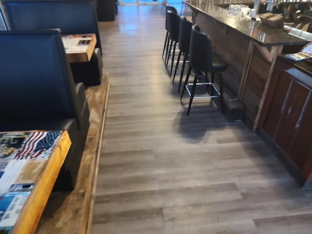 Commercial-grade glue-down LVP flooring between the booths and the bar of Nonna Picci pizza restaurant in Statesboro GA