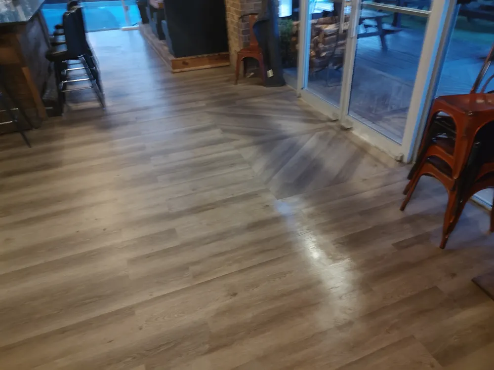 Commercial-grade glue-down LVP with an angled inlay at the patio doors of Nonna Picci pizza restaurant in Statesboro GA