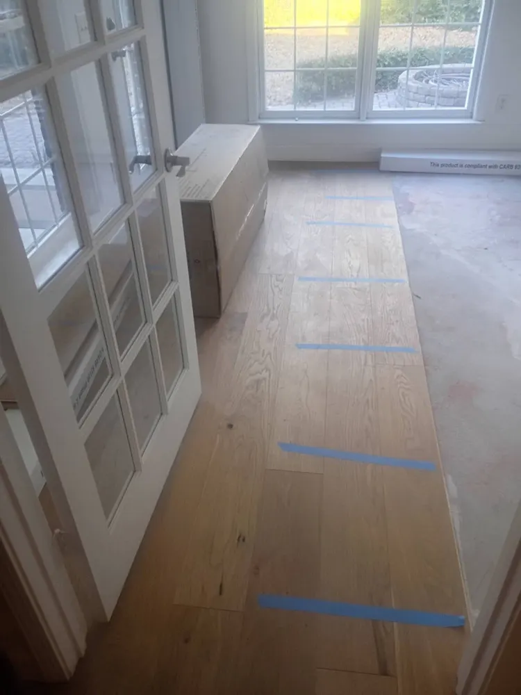 Engineered wood planks being glued down in a room with French doors in Irongate, Statesboro GA