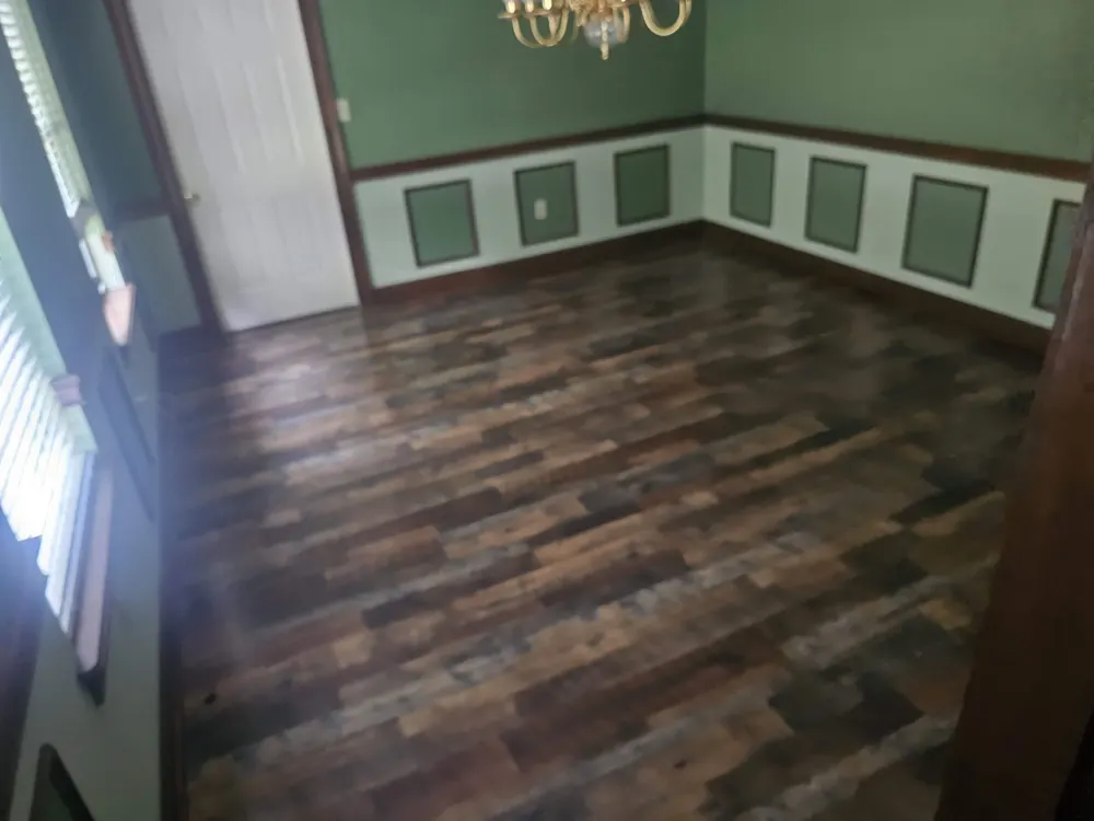 Rustic luxury vinyl plank flooring in a dining room with wainscoting in Old Mill, Statesboro GA